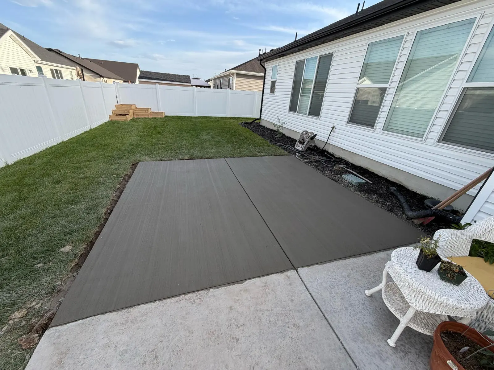 Broom-finished concrete patio extension added to an existing backyard slab
