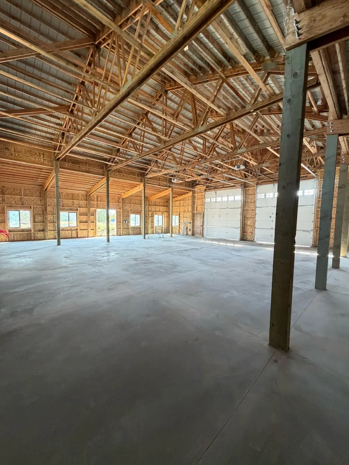 Large interior concrete floor slab inside a finished pole barn workshop