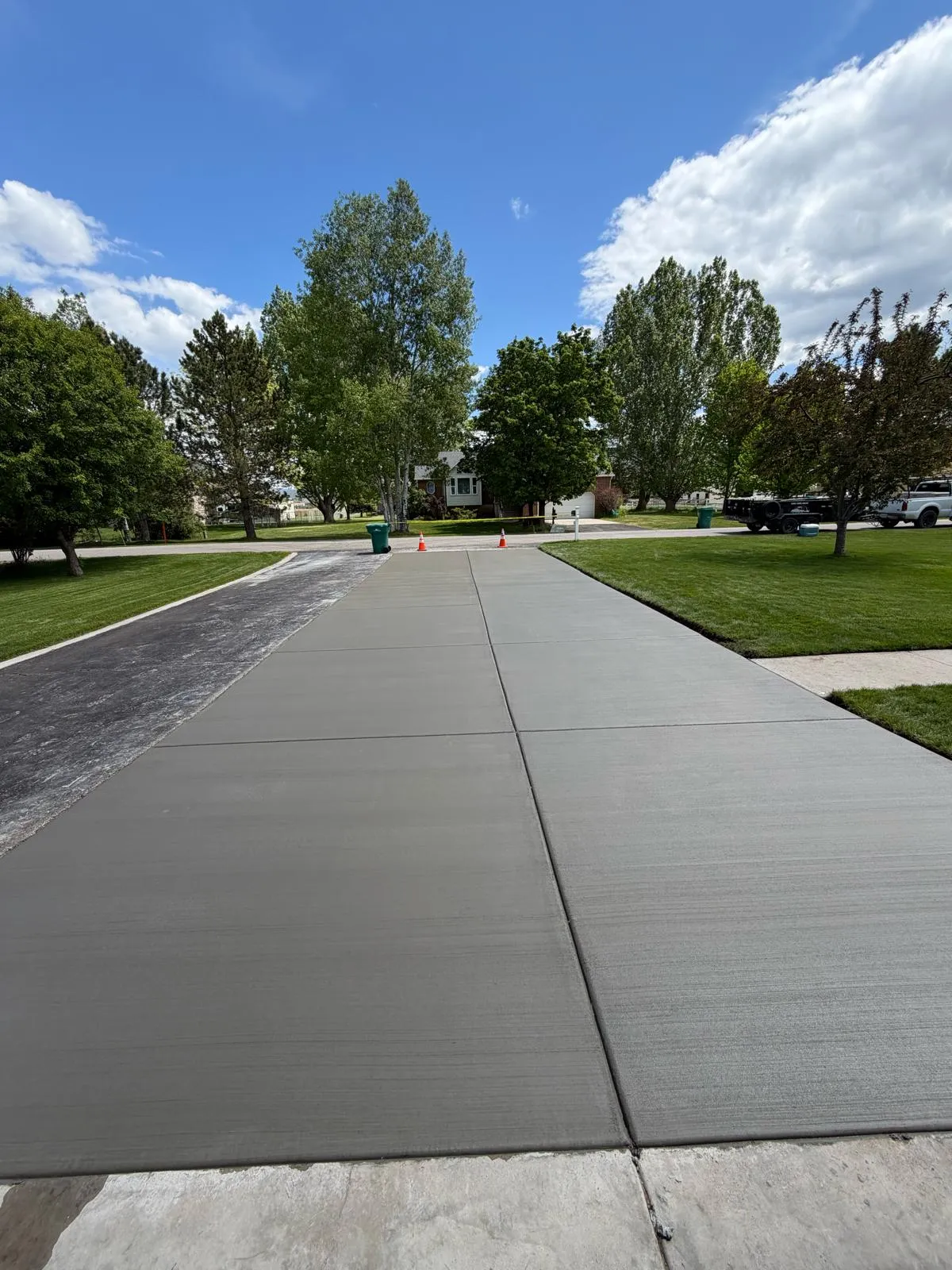 Wide broom-finished concrete driveway replacement leading to the street